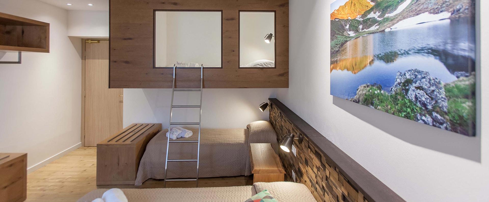 Cozy room with bunk beds, warm wood, and mountain landscape.
