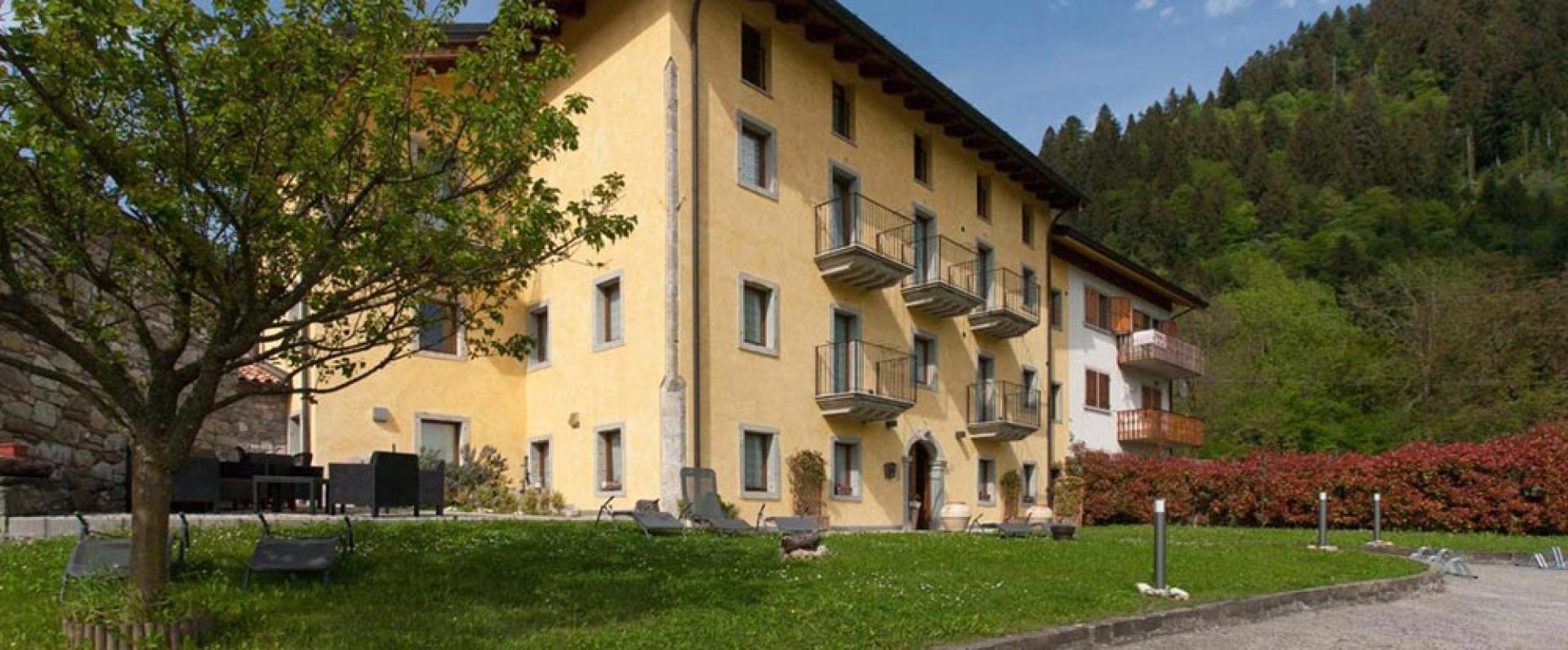 Gelbes Gebäude in den Bergen, ruhige Atmosphäre und üppiges Grün.