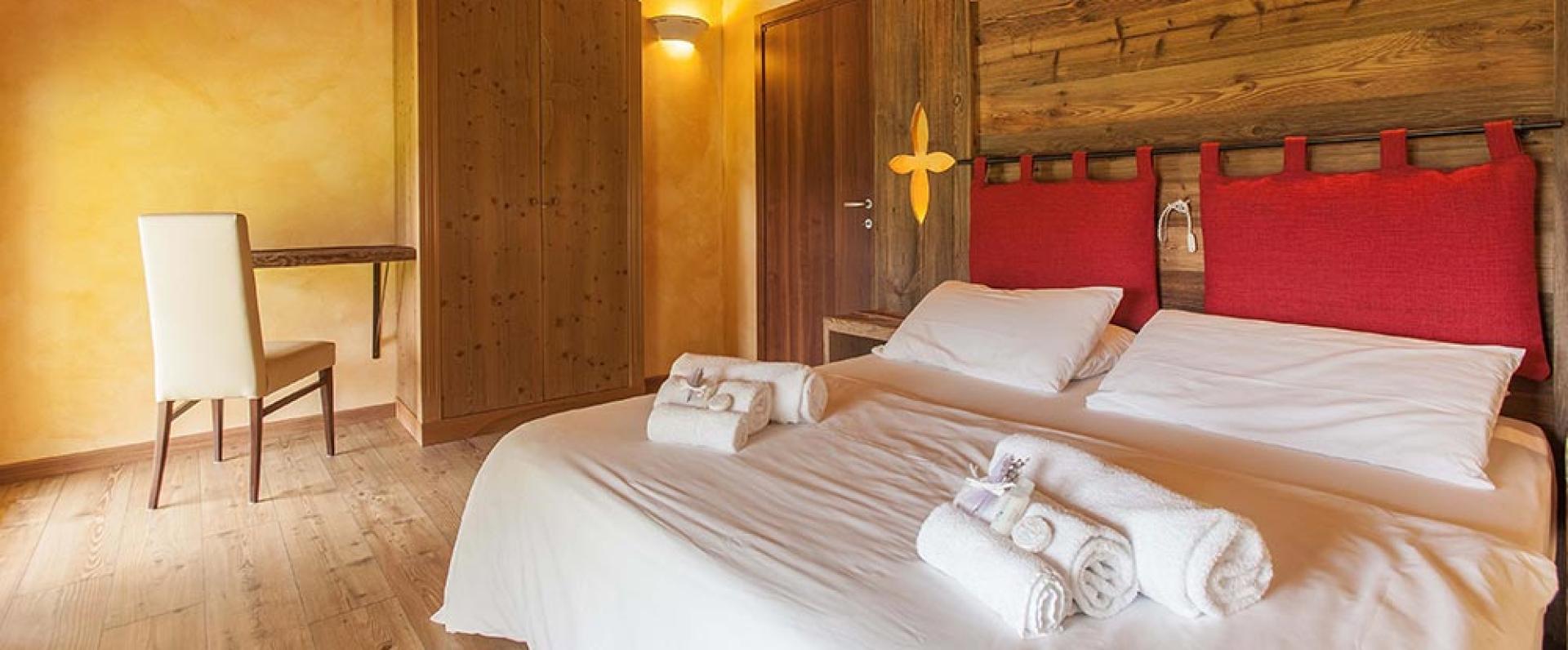 Gemütliches Zimmer mit Doppelbett, warmem Holz und leuchtenden Details.