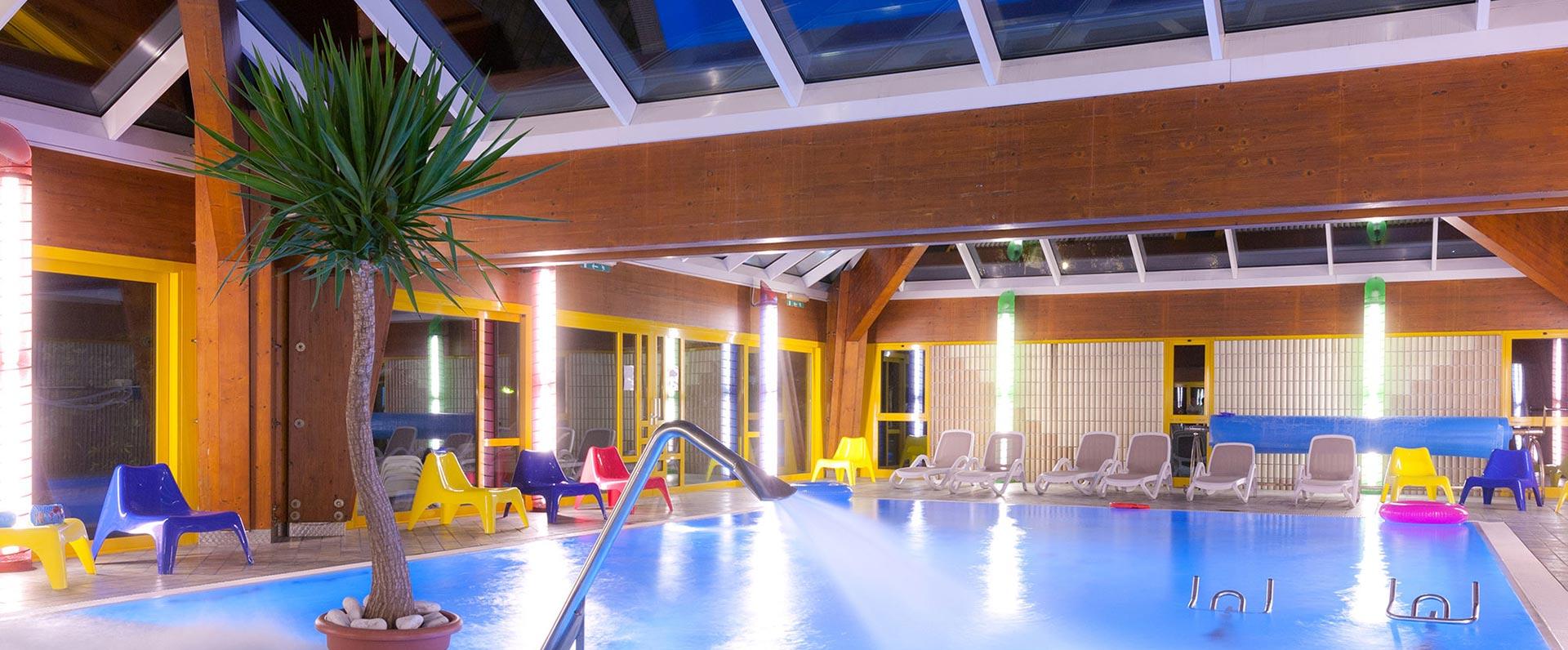 Bright indoor pool with colorful chairs and a relaxing atmosphere.